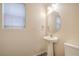 Bright half bath features a pedestal sink, decorative mirror, and updated fixtures at 137 Desert Pond Ave, Henderson, NV 89002