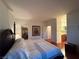 Spacious bedroom featuring hardwood floors, walk-in closet, ensuite bathroom, and unique floral artwork at 141 Gryffin Ave, Las Vegas, NV 89123