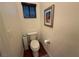 Toilet with dark wood laminate floors, flower painting, and window with light blocking shades at 141 Gryffin Ave, Las Vegas, NV 89123