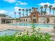 Community pool and jacuzzi area with lounge chairs surrounded by a building and palm trees at 1525 Spiced Wine Ave # 10102, Henderson, NV 89074