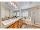 Bright bathroom featuring double sinks, granite countertops, and a separate bathtub and glass-enclosed shower at 173 Calm Morning Ave, Henderson, NV 89002