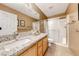 Well-lit bathroom featuring a granite countertop vanity, shower and tiled floors at 173 Calm Morning Ave, Henderson, NV 89002
