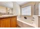 Bathroom featuring granite countertops, a soaking tub, and a vanity with wood cabinets at 173 Calm Morning Ave, Henderson, NV 89002