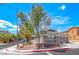Corner lot home featuring desert landscaping, covered porch, and a community gate in the background at 173 Calm Morning Ave, Henderson, NV 89002