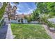 Spacious backyard featuring lush green grass, mature trees, and an outdoor play structure at 176 Tierra Bonita Ct, Henderson, NV 89074