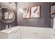 Well-lit bathroom with white vanity, octagonal mirror, and framed art for a stylish look at 176 Tierra Bonita Ct, Henderson, NV 89074