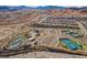 Aerial view of a desert community featuring a pool, tennis courts, and lush desert landscaping at 19 Desert Ivy Ln, Henderson, NV 89011