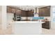 Modern kitchen features dark wood cabinetry, stainless steel appliances, and a large white island with sink at 19 Desert Ivy Ln, Henderson, NV 89011