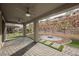 Wide angle shot of the patio with stone pavers and a walkway leading to a firepit with green accents at 19 Desert Ivy Ln, Henderson, NV 89011