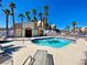 Community pool with clear blue water and palm trees set against a blue sky at 2044 Mesquite Ln # 202, Laughlin, NV 89029