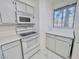 Kitchen featuring white appliances and countertops, complemented by views of lush palm trees visible through the window at 2044 Mesquite Ln # 202, Laughlin, NV 89029