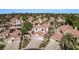 Aerial view featuring a residential neighborhood with terracotta roofs, palm trees, well-manicured landscaping, and mountain views at 227 Drysdale Cir, Henderson, NV 89074