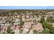 A vast aerial view showcases a community of homes with red-tiled roofs, complemented by lush greenery and mountain vistas at 227 Drysdale Cir, Henderson, NV 89074
