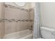 Bright bathroom showcasing a tiled tub and shower, a toilet, and a tiled accent wall at 227 Drysdale Cir, Henderson, NV 89074