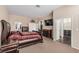 Spacious bedroom featuring a luxurious king bed, adjoining spaces, a TV, and matching furniture at 227 Drysdale Cir, Henderson, NV 89074