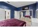 Bedroom with blue walls, carpet, mirrored closet doors, and a mounted TV for easy viewing at 227 Drysdale Cir, Henderson, NV 89074