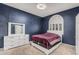 Comfortable bedroom with navy blue walls, plush carpet, and a large window with a decorative arch at 227 Drysdale Cir, Henderson, NV 89074