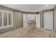 Spacious bedroom with plush carpeting, shuttered windows, and an open doorway to another living space at 227 Drysdale Cir, Henderson, NV 89074