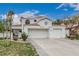 Elegant two-story home featuring a tile roof, an attached two-car garage, and desert landscaping at 227 Drysdale Cir, Henderson, NV 89074