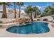 Backyard pool featuring rock waterfall, water feature, and lush palm trees creating a private oasis at 227 Drysdale Cir, Henderson, NV 89074