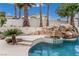 Beautiful pool with a rock waterfall feature and lush landscaping creating a tranquil backyard oasis at 227 Drysdale Cir, Henderson, NV 89074
