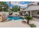 Inviting pool area with a waterfall feature, lush landscaping, and ample space for lounging and recreation at 227 Drysdale Cir, Henderson, NV 89074