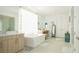 Bright bathroom featuring a freestanding tub, double vanity, makeup vanity, glass-enclosed shower, and tiled floor at 230 Carmel Sky St, Las Vegas, NV 89138