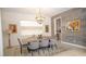 Bright dining area featuring contemporary decor, a modern chandelier, and a light wood table at 230 Carmel Sky St, Las Vegas, NV 89138
