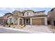 Charming two-story house featuring a brick driveway, modern garage, and stylish desert landscaping at 230 Carmel Sky St, Las Vegas, NV 89138