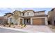 Gorgeous two-story house featuring a brick driveway and modern-designed garage with stylish desert landscaping at 230 Carmel Sky St, Las Vegas, NV 89138