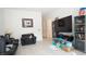 Cozy living room featuring comfortable seating, a large TV, and ample storage space for entertainment at 230 Carmel Sky St, Las Vegas, NV 89138