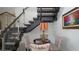 Modern staircase with glass railings and a seating area with a lamp and decorative chairs at 230 Carmel Sky St, Las Vegas, NV 89138