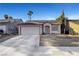 View of a single-story home with desert landscaping, a two-car garage, and solar panels at 2504 Soldier Creek Ct, Las Vegas, NV 89106