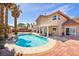 Lush backyard with a pristine pool, covered patio, and mature trees for a serene outdoor experience at 266 Cordero Dr, Henderson, NV 89074