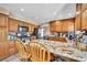 Traditional kitchen with wooden cabinets, granite countertops, stainless steel appliances and breakfast bar at 266 Cordero Dr, Henderson, NV 89074