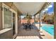 Relaxing covered patio with dining area, string lights, and view of sparkling blue swimming pool at 266 Cordero Dr, Henderson, NV 89074