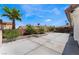 Expansive backyard with concrete patio, raised planters, greenery, and shade structure against a backdrop of blue sky and palm trees at 2803 Marathon Dr, Henderson, NV 89074