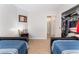 Comfortable bedroom featuring twin beds with blue bedding, a closet, and a well-lit hallway at 2803 Marathon Dr, Henderson, NV 89074