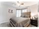 Bright bedroom featuring a ceiling fan, soft gray walls and a neutral toned platform bed with a tufted headboard at 2803 Marathon Dr, Henderson, NV 89074