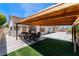 Inviting covered patio featuring an outdoor dining set and an artificial grass area for relaxed outdoor gatherings at 2803 Marathon Dr, Henderson, NV 89074
