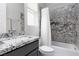 Modern bathroom with granite counters, gray cabinets, and a stylishly tiled shower/tub combo at 292 Crimson Edge St, Henderson, NV 89012
