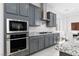 Stylish kitchen showcasing stainless steel appliances, gray cabinetry, and granite countertops at 292 Crimson Edge St, Henderson, NV 89012
