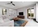 Comfortable living room featuring a ceiling fan, large tv, and sliding doors to the backyard at 292 Crimson Edge St, Henderson, NV 89012