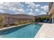 Beautiful backyard featuring a pool, spa, landscaping, mountain views, and outdoor seating area at 292 Crimson Edge St, Henderson, NV 89012
