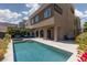 Exterior view of a home featuring a pristine pool, a covered patio, and lush landscaping at 292 Crimson Edge St, Henderson, NV 89012