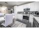 Modern kitchen featuring white cabinetry, stainless steel appliances, and a cozy dining area for Gathering meals at 3018 Sunrise Bay Ave, North Las Vegas, NV 89031