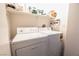 Efficient laundry room with white washer, dryer and storage shelves for supplies at 3018 Sunrise Bay Ave, North Las Vegas, NV 89031