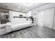 Open-concept living space includes modern white furniture, kitchen with stainless steel appliances, and sleek hardwood-style floors at 3018 Sunrise Bay Ave, North Las Vegas, NV 89031