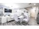 Open living area with a white dining table, a sleek entertainment center, and modern decor throughout at 3018 Sunrise Bay Ave, North Las Vegas, NV 89031
