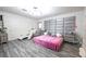 Bright and airy main bedroom with hardwood-style floors, upholstered headboard, and views of a chaise lounge and dresser at 3018 Sunrise Bay Ave, North Las Vegas, NV 89031
